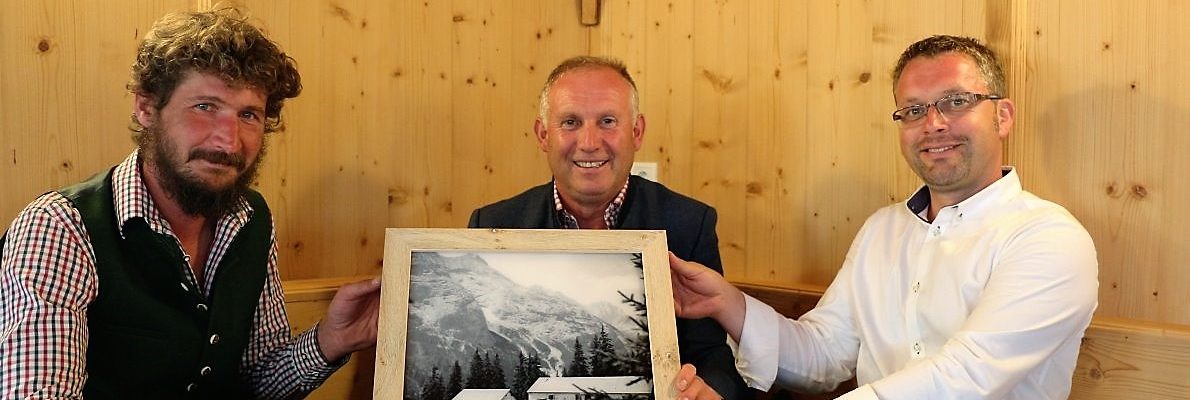 Das Bild der Scharmer Abba hängt an seinem Platz. Überreicht an Almhirt Martin Reich (links) von Almobmann Klaus Scharmer und Vize-Bgm. Martin Kapeller. (Foto: Knut Kuckel)